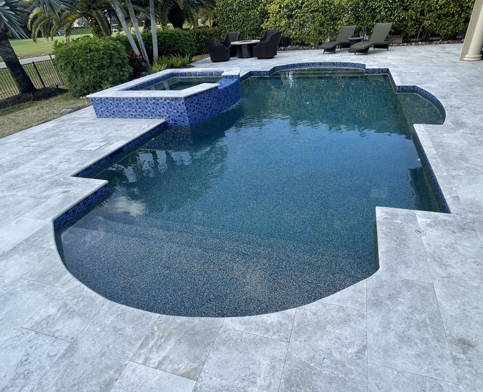Custom pool and spa with sun shelf loungers overlooking a golf course in Southwest Florida